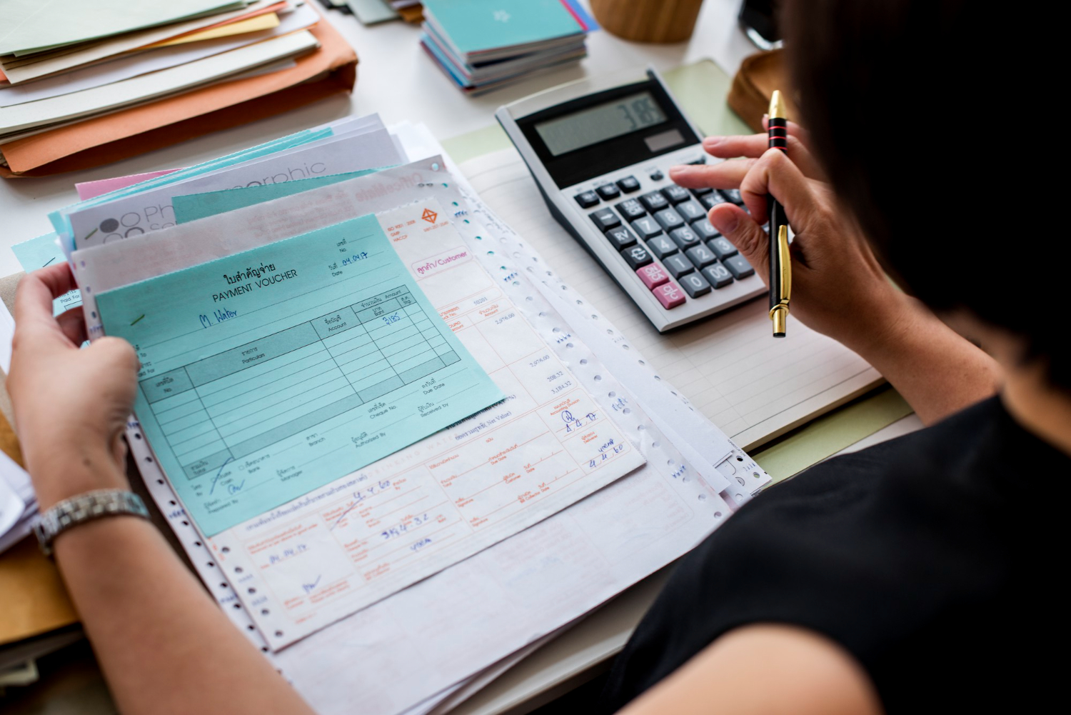 Foto grátis mulher asiática trabalhando na papelada de uma empresa em uma mesa com uma calculadora e outros papéis