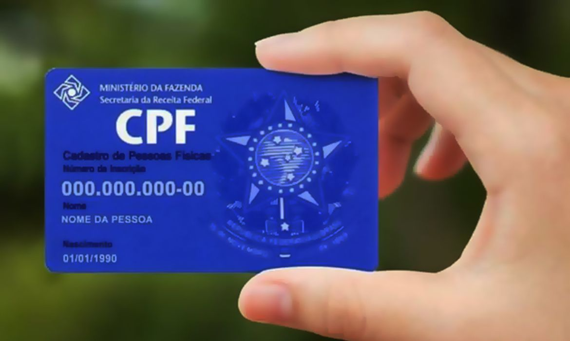 mãos de uma pessoa segurando um CPF sem números