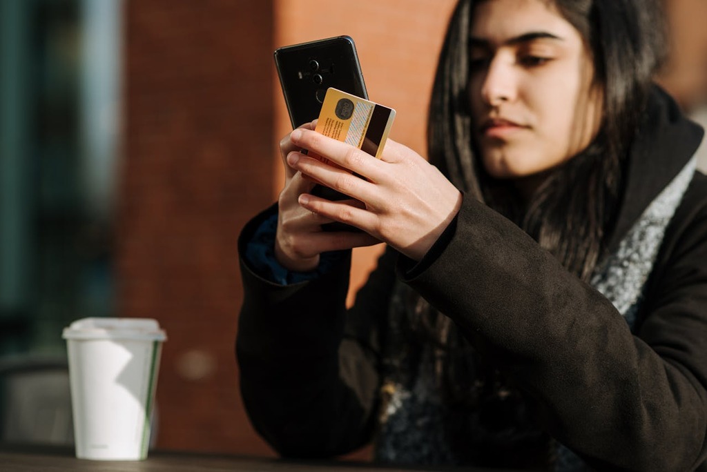 mulher usando celular para solicitar cartão de lojas
