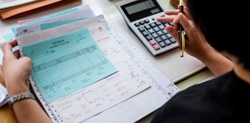 Foto grátis mulher asiática trabalhando na papelada de uma empresa em uma mesa com uma calculadora e outros papéis