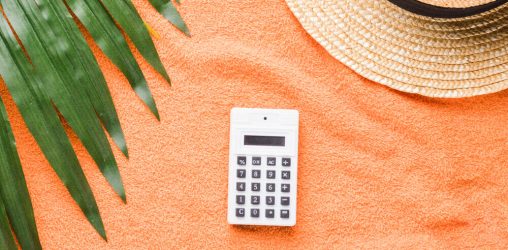 calculadora e chapeu de praia em fundo laranja