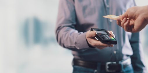 pessoa passando cartão na maquininha, representando como como ganhar dinheiro com cartão de crédito