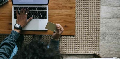 pessoa usando o computador para aprender como usar um cartão de crédito