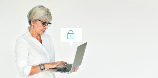 mulher de cabelos brancos olhando para o laptop em sua mão e pensando em segurança de dados enquanto aparece o ícone de cadeado