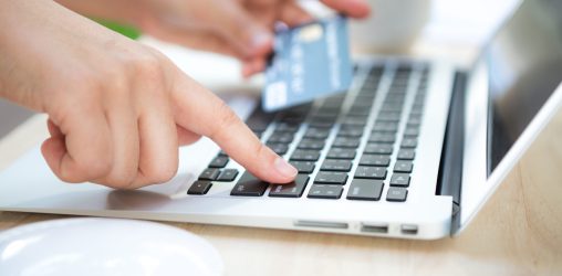 Mão segurando cartão de crédito para empréstimo online