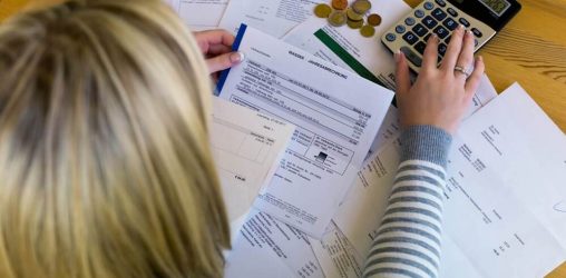 Mulher usando calculadora para organizar finanças