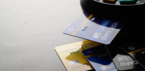 maquina de cartão de crédito com vários cartões de crédito e débito embaixo