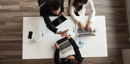 Três pessoas em um ambiente de trabalho prestando serviços financeiros
